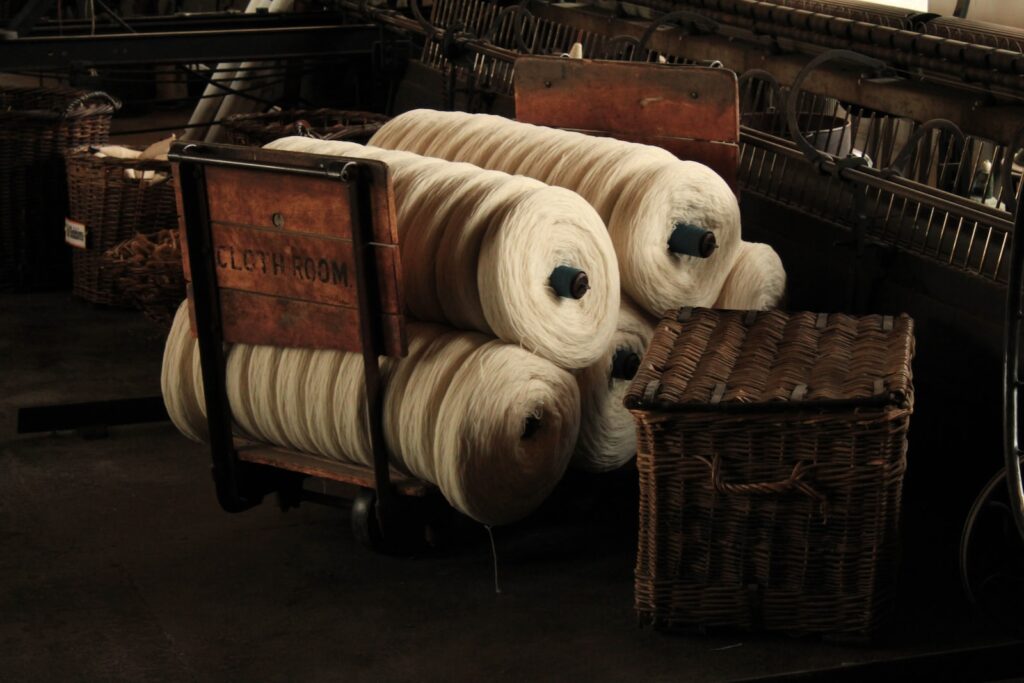 several rolls of yarn sitting on top of a wooden cart