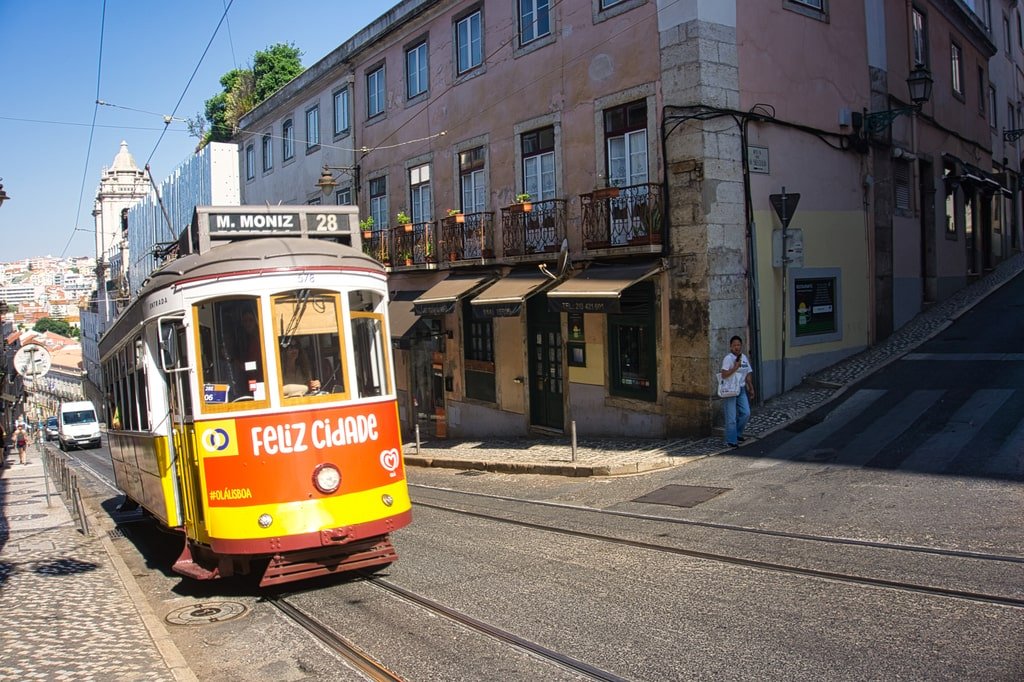 A number 28 tram moves through the streets of Lisbon.