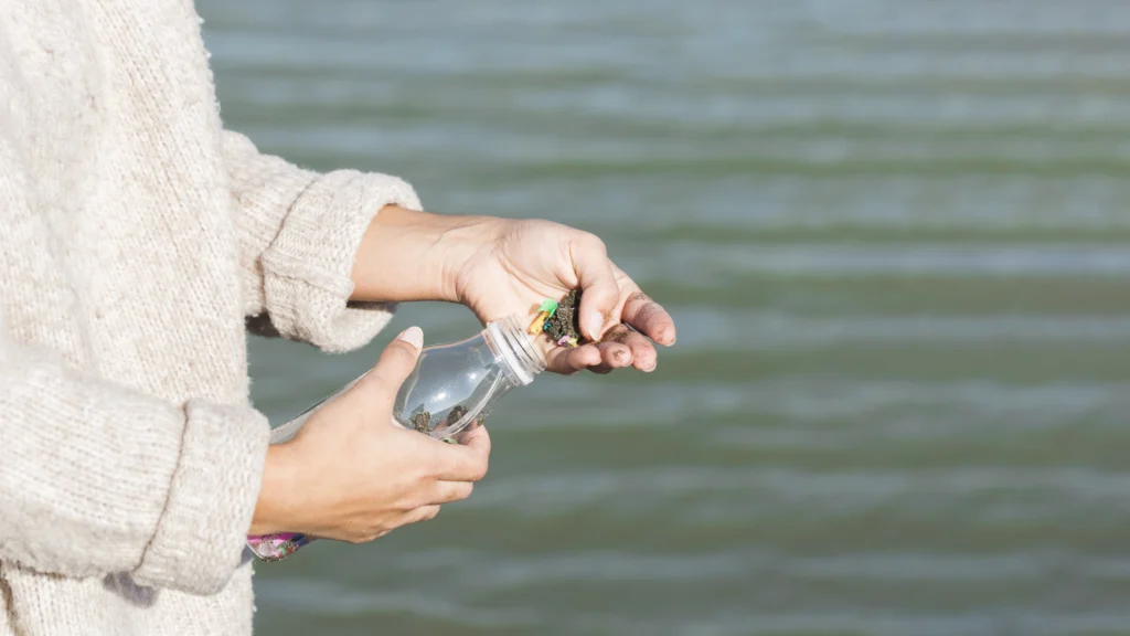 woman-cleaning-sea-plastic-bottle